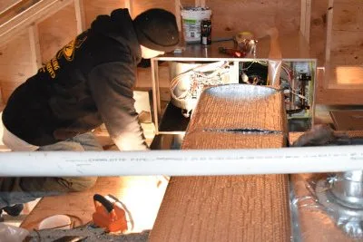 A&L technician servicing a system in an attic